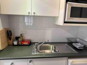 a kitchen counter with a sink and a microwave at By the Harbour Gem in Sydney