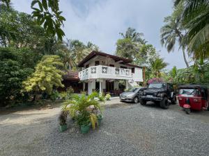 a house with cars parked in front of it at Solal Villa in Aluthgama