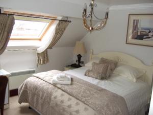 a bedroom with a bed with a window and a white bedspread at Moss Lodge in Rochdale