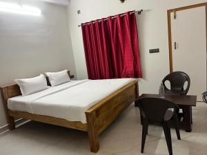 a bedroom with a bed and a red curtain at Shree stay in in Chikmagalūr