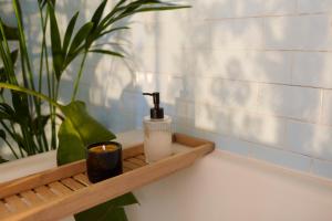 a wooden tray with a soap dispenser and a candle at Alma ART B&B in Dobrovo