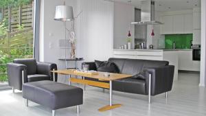 een woonkamer met een bank en een tafel en stoelen bij Triton Suite in Eckernförde