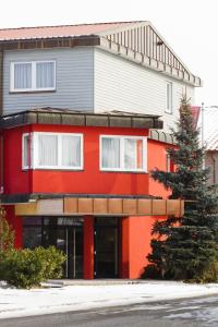 ein rotes Gebäude mit einem Baum davor in der Unterkunft Fritz Hotel & Restaurant KG in Weil am Rhein