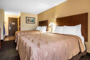a hotel room with two beds with white pillows at Quality Inn Janesville North in Janesville