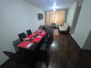 a dining room with a long table with red tables and chairs at RODRICH apartment 2 in Lima