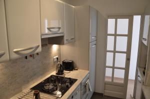 een keuken met witte kasten en een fornuis met oven bij Spacieux & Lumineux appartement - Centre de Cannes in Cannes