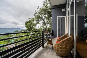 a balcony with chairs and a view of the mountains at Alaya Stays Trios Top Pet Friendly Apartments in Mukteswar
