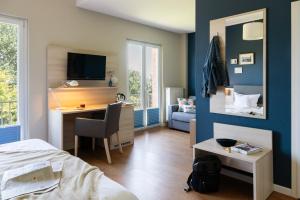 a bedroom with a bed and a desk with a tv at Hotel Alte Fischereischule in Eckernförde