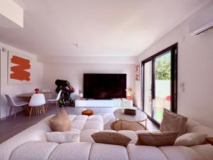 a living room with a large couch and a table at Belle chambre dans villa neuve avec piscine in Perpignan