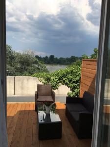 eine Terrasse mit einem Sofa und einem Stuhl auf dem Balkon in der Unterkunft Apartment 'Rheinblick' mit grosser Terrasse in Mainz