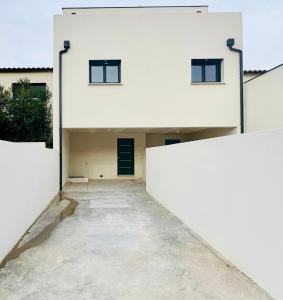 a white building with a hallway leading to a door at Belle chambre dans villa neuve avec piscine in Perpignan