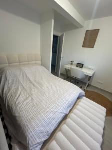 a white bedroom with a bed and a desk at Belle chambre dans villa neuve avec piscine in Perpignan +11 photos