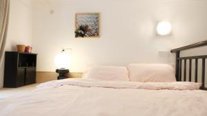 a bed with white sheets and pillows in a bedroom at FFC sweet home on Shaanxi Road in Shanghai