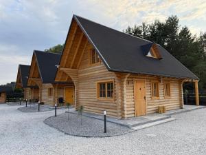 a log cabin with a black roof at Balujemy w Radawie in Radawa
