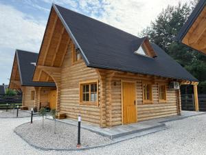 a small log cabin with a black roof at Balujemy w Radawie in Radawa