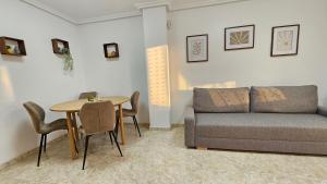 una sala de estar con un sofá y una mesa en Cozy apartment beach 300 metros, en Santa Pola