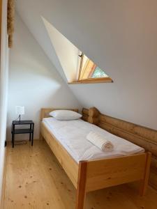 a bedroom with a bed with a skylight at Balujemy w Radawie in Radawa