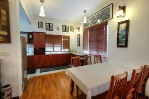 a dining room with a table and a kitchen at Holiday Bungalow Suites - Sleeps Up To 26 Pax in Tanah Rata +25 photos