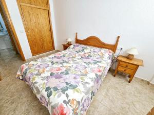 Un dormitorio con una cama con un edredón floral. en Cozy apartment beach 300 metros, en Santa Pola