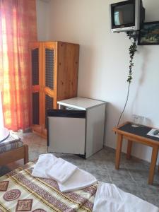 a room with a bed and a tv and a table at Complex Laguna-Kantardzhiev in Primorsko
