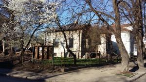 an old white house with trees in front of it at Hostel MIF in Ivano-Frankivsʼk