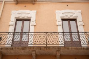 two windows on a building with a balcony at campo appartamenti in Trapani