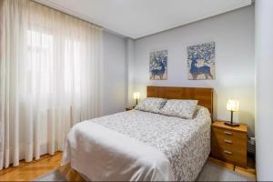 a bedroom with a white bed and a window at San vicente centro l 1000 metros playas in San Vicente de la Barquera