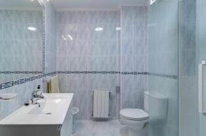 a bathroom with a toilet and a sink and a shower at San vicente centro l 1000 metros playas in San Vicente de la Barquera