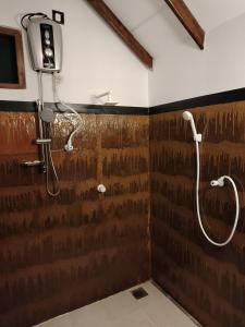 bagno con doccia e parete marrone di Sigiriya Nature Resort a Sigiriya Altre 37 foto