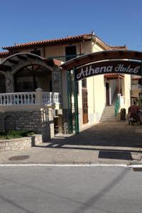 a store with a sign on the front of a building at Hotel Athena in Kokkari