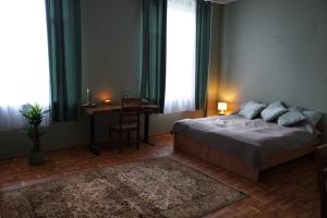 a bedroom with a bed and a table and a desk at Meirānu muiža in Meirāni
