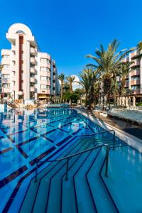 a large swimming pool with palm trees and buildings at Hotel Aqua in Marmaris