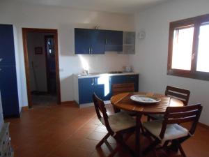 a kitchen with a wooden table and a table and chairs at Villino Caddu in San Teodoro