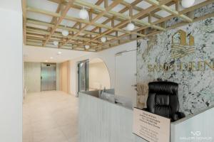 a waiting area with a black chair in a lobby at Sand Dunes Blue Marine by Major Domus Club in Dziwnów
