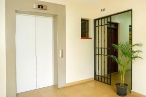 a hallway with a glass door and a potted plant at Stylish Nairobi CBD Studio with Fast Wi-Fi & Netflix in Nairobi
