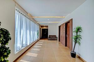 a hallway with a couch and large windows at Hotel O The Grand Imperial Restaurant & Hotel Dhuva Railway station in Morbi