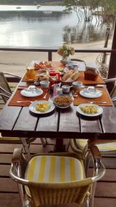 uma mesa de madeira com pratos de comida em Club MV Saco do Céu em Abraão