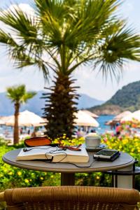 a table with a book and a coffee cup on it at Hotel Aqua in Marmaris