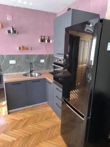 a kitchen with a black refrigerator and a sink at Apartments Ribić in Umag