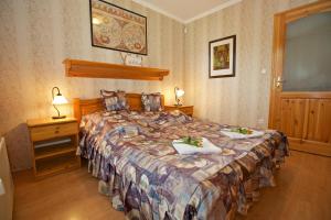 a bedroom with a large bed with two dishes on it at Harmónia Apartmanház in Hajdúszoboszló