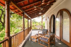 a porch with two chairs and a table at La Selva - 4BHK Luxury Villa in Assagao with Private Pool near Cafés & Soro Pub in Assagao