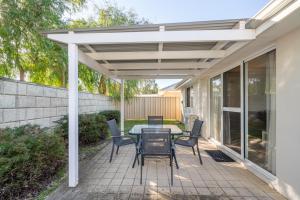 a white pergola on a patio with a table and chairs at Ocean Blue Bungalow Easy Beach Stay in Busselton in Broadwater