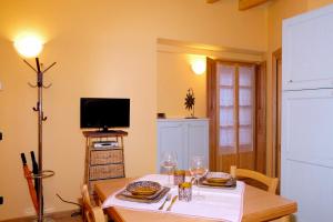 a dining room with a table and a tv at Casa Aurora in Cannobio