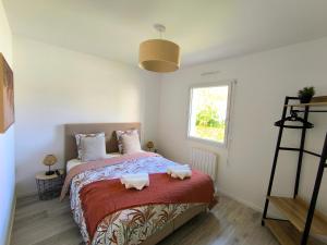 a bedroom with a bed with two towels on it at Les Rochers - Raffinement boisé & Plage à 5 min en voiture - Sérénité in Brétigny