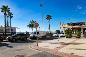 a stop sign in front of a parking lot with palm trees at RIO SECO LOFT BEACH- HOME RENt MALAGA in Torre del Mar