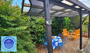 a wooden pergola with a table and chairs in a yard at EntreLac&Océan1 - chambre d'hôtes chez l'habitant, Entrée et terrasse privée- cyclotouristes bienvenue in Aureilhan
