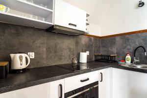 マウェ・チヘにあるApartament z widokiem na góry u Bronkaの白いキャビネットと黒いカウンタートップを備えたキッチン +6枚の写真
