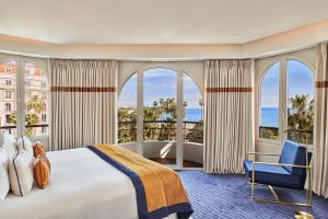 a hotel room with a bed and large windows at Hôtel Barrière Le Majestic Cannes in Cannes