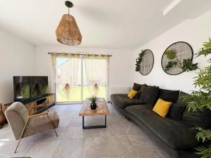 a living room with a couch and a table at Les Rochers - Raffinement boisé & Plage à 5 min en voiture - Sérénité in Brétigny