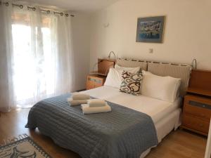 a bedroom with a bed with two towels on it at Villa Ampelaki "30 meters to beach" in Paleokastritsa